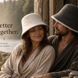 May include: A couple wearing matching bucket hats and robes. One hat is light beige with a gray brim, the other is dark gray with a white brim. The image includes the text "Better together. Shared rituals. Natural comfort."