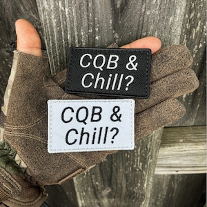 May include: Two rectangular morale patches with embroidered borders. One patch is black with white text reading CQB & Chill?, and the other is white with black text reading CQB & Chill?. Both patches feature a clean, bold font and a fabric texture.