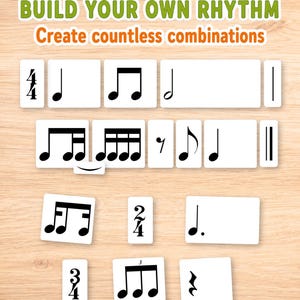 Puede incluir: Un conjunto de tarjetas rectangulares blancas con símbolos de notación musical en negro, incluyendo compases, notas y silencios. El texto BUILD YOUR OWN RHYTHM y Create countless combinations aparece impreso en la parte superior.