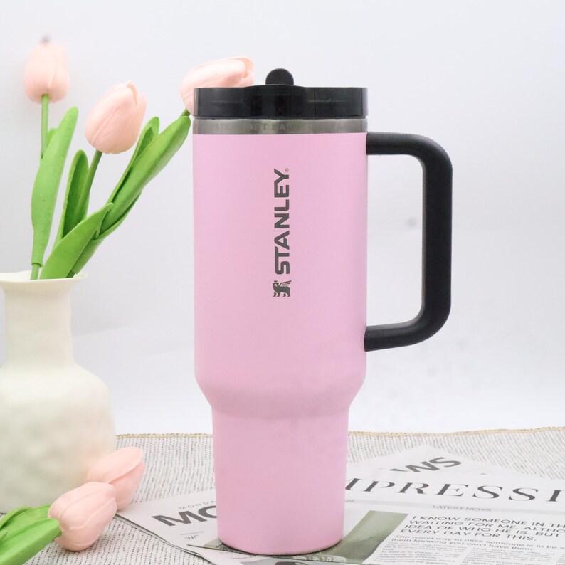 Pu&ograve; includere: Una tazza da viaggio Stanley rosa con manico e coperchio neri. La tazza presenta il logo Stanley. La tazza cilindrica ha una base affusolata ed &egrave; progettata per bevande calde o fredde. &Egrave; alta circa 23 cm.