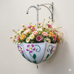 May include: A white metal umbrella-shaped wall planter filled with colorful flowers. The planter has a distressed finish and is decorated with purple and yellow flower designs. The planter is suspended from a decorative metal bracket.