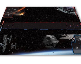 以下が含まれることがあります： スターウォーズをテーマにしたゲームマット。TIEファイター、デス・スター、スター・デストロイヤーが登場する宇宙戦闘シーンが描かれています。マットには赤と青のボーダーとゲームプレイエリアがあります。