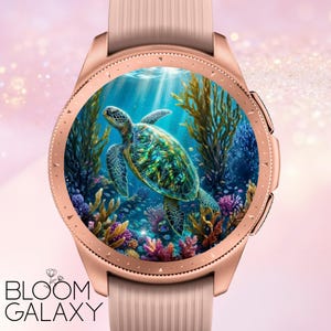Op de afbeelding: Roségouden smartwatch met een lichtroze band. De wijzerplaat toont een levendige onderwaterwereld met een zeeschildpad, koraal en zeewier. De tekst "BLOOM GALAXY" staat onderaan de wijzerplaat.