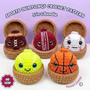 Op de afbeelding: Een 5-in-1 bundel met haakpatronen voor sport-dumplings, bestaande uit vijf gehaakte ballen: een bruine football, een rode cricketbal, een witte honkbal, een neongele tennisbal en een oranje basketbal, elk in een bruine gehaakte houder.