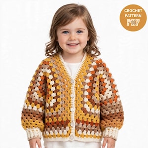 May include: A crochet pattern PDF for a long-sleeve cardigan featuring a granny square motif in shades of mustard yellow, burnt orange, brown, and cream. The cardigan has a V-neckline, a button-front closure with four buttons, and ribbed cuffs.