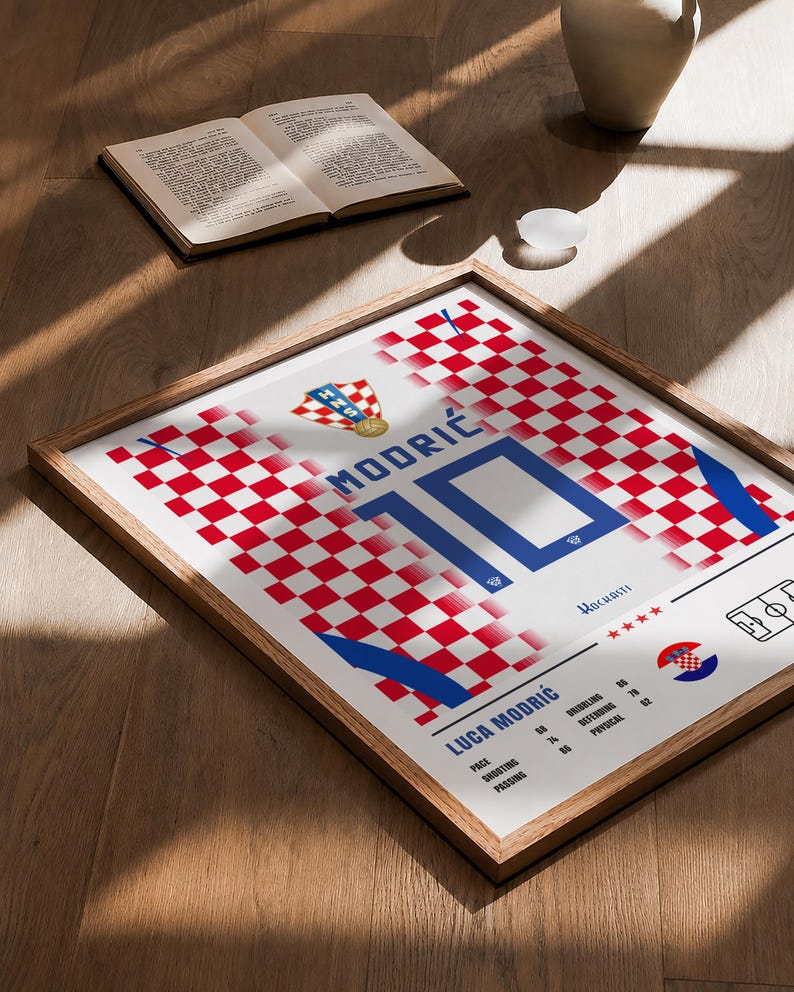 May include: A framed poster featuring a red and white checkered pattern inspired by the Croatian national football jersey. It displays the name MODRIĆ, the number 10, the text LUCA MODRIĆ, player statistics, the HNS crest, and four red stars.