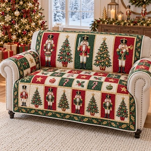 May include: A quilted sofa cover featuring a festive pattern of nutcracker figures, decorated Christmas trees, candy canes, and ornaments in red, green, and cream colors. The fabric has a repeating grid design with holly leaf accents.