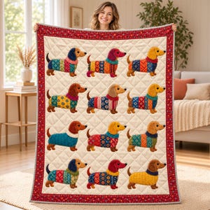 May include: A quilted throw blanket featuring a cream-colored background with a diamond-stitched pattern. The quilt displays twelve embroidered dachshund dogs, each wearing a sweater with various colorful, intricate geometric patterns.