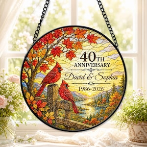 May include: A circular stained glass suncatcher featuring two red cardinals perched on a wooden fence. The scene depicts an autumn landscape with maple leaves, a lake, and mountains. Text reads 40TH ANNIVERSARY, David & Sophia, 1986-2026.