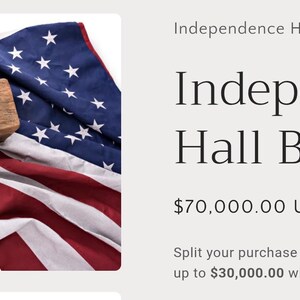 May include: A weathered wooden beam with two carved openings rests atop a folded American flag. The flag displays red and white stripes and a blue field with white stars. The text "Independence Hall Beam" is visible.