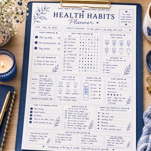 May include: A blue and white Health Habits Planner with a gold clip, featuring sections for daily habits, water intake, and sleep tracking. The planner includes a notepad, a pen, a candle, and a cup of coffee.