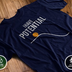 May include: A navy blue t-shirt with the text "I HAVE POTENTIAL" in white lettering. A white line curves upward with a yellow circle at the bottom of the curve.