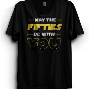 May include: Black t-shirt with a yellow graphic that says "May the Fifties Be With You".