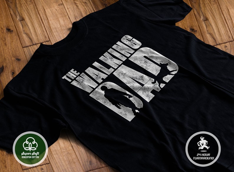 Puede incluir: Camiseta negra con un gr&aacute;fico blanco que dice "The Walking Dad" con una silueta de una persona y un perro.
