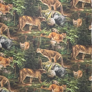 May include: A fabric featuring a repeating pattern of cougars in a forest environment. The cougars are depicted in shades of brown and tan, set against a backdrop of green foliage, rocks, and trees. The image has a realistic, detailed style.