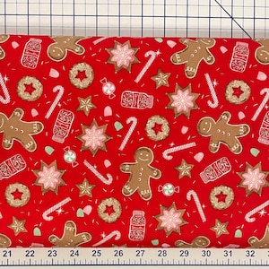May include: Red fabric with a repeating pattern of gingerbread men, candy canes, stars, and cookies. The fabric is perfect for holiday crafts and quilting.