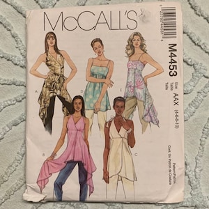 May include: A sewing pattern for a wrap top with a variety of styles. The pattern is for sizes 4-6-8-10 and is called McCall's M4453 AAX.