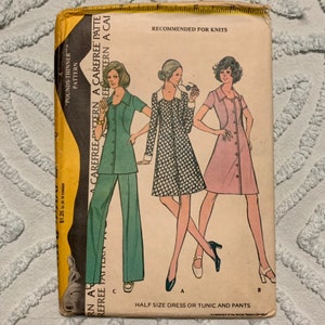 May include: Vintage sewing pattern for a half-size dress or tunic and pants. The pattern is recommended for knits and features a button-up design. The pattern is illustrated with three women wearing the different styles.