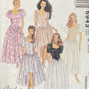 May include: A McCall's 6943 sewing pattern envelope featuring illustrations of five different dress styles with sweetheart necklines, puff sleeves, and varying skirt lengths, including floral prints and solid color combinations for petite sizes.