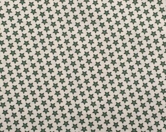 May include: White fabric with a repeating pattern of small, dark green stars.