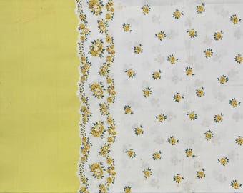 Peut inclure: Un tissu blanc avec un motif floral jaune et une bordure jaune. Le motif floral présente des roses jaunes avec des feuilles vertes. La bordure a un bord festonné. Le tissu est probablement utilisé pour la décoration intérieure ou l'artisanat.