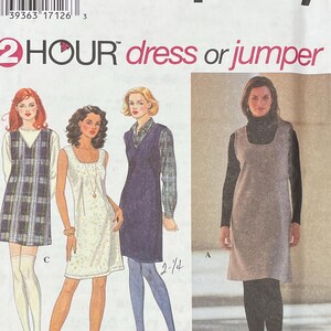 May include: A sewing pattern for a dress or jumper. The pattern includes three different styles: a plaid dress, a white dress with a lace overlay, and a solid gray dress. The pattern is for sizes 10, 12, and 14. The pattern is from Simplicity and is called "2 Hour Dress or Jumper".