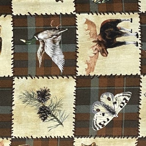 May include: A patchwork fabric design featuring a brown and green plaid pattern with images of a flying duck, a moose, a pine branch with pine cones, and a white butterfly.