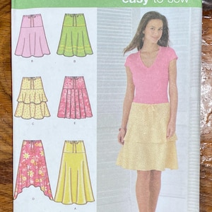 May include: A sewing pattern for a skirt with five different styles. The pattern is for sizes 8, 10, 12, and 14. The pattern is from Simplicity and is easy to sew.