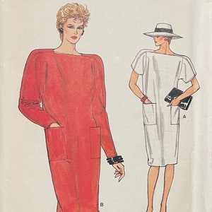 May include: Illustration of two dresses. One is a long-sleeved, red dress with a square neckline and large pockets. The other is a short-sleeved, white dress with a square neckline and pockets. Both dresses have a simple, classic design.