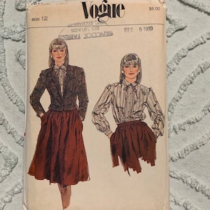 May include: Vintage Vogue sewing pattern for a skirt and blouse. The pattern is size 12 and is dated December 6, 1990. The pattern shows two women wearing the skirt and blouse. The skirt is a brown A-line skirt and the blouse is a striped white and brown blouse with a bow tie.