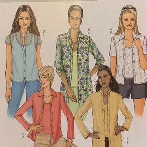 May include: Five different women's tops with button fastenings. The tops are in various colours and patterns, including a light blue top, a green and purple floral print top, a white top with a floral pattern, a pink top, and a beige top.