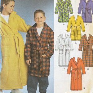 May include: A sewing pattern envelope featuring illustrations of bathrobes in various styles and colors, including solid yellow, purple, orange, white, and plaid patterns. The cover displays a yellow robe and a plaid robe with matching tie belts.