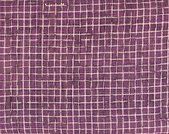 May include: Close-up of a purple fabric with a grid pattern. The grid is formed by thin white lines that intersect to create small squares. The fabric has a textured appearance, and the grid lines are slightly irregular, giving it a handmade look.