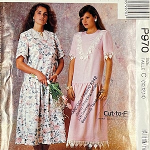 May include: Two women modeling dresses from a sewing pattern. One dress is white with a pink floral pattern, the other is pink with white lace trim. The pattern is labeled P970, size C (10,12,14).