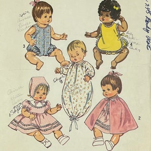 May include: Illustration of five baby dolls in various outfits. One doll wears a pink dress and bonnet, another a blue gingham romper, and a third a yellow dress. The other two dolls are wearing a pink cape and a floral print sleep sack.