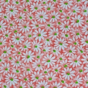 May include: A red fabric with a white daisy pattern. The daisies have green centers.