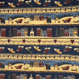 May include: A repeating pattern depicting a winter village scene with houses, angels, snowmen, and sleighs. The design includes a navy blue background with cream-coloured borders and decorative elements like hearts and bells. The overall theme is festive and seasonal.