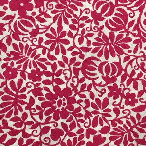 May include: A white fabric with a pink floral pattern. The pattern features leaves, flowers, and swirls.