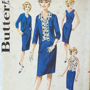 May include: Three vintage sewing patterns for women's dresses. The patterns are from Butterick and feature a blue and white floral design. The patterns are for a dress with a jacket, a dress with a skirt, and a dress with a sleeveless top.
