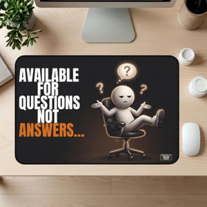 May include: A black rectangular desk mat featuring a white cartoon character sitting in a black office chair with a shrug gesture. The text reads AVAILABLE FOR QUESTIONS NOT ANSWERS in white and orange. Three question marks float above the character.