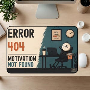 May include: A rectangular desk mat featuring the text ERROR 404 MOTIVATION NOT FOUND in black and orange. The graphic depicts a cartoon character sitting at a desk with a laptop, a coffee cup, a wall clock, and a sign that reads FOCUS LOADING.