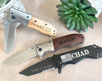 May include: Three pocket knives with personalized engravings. The first knife has a wooden handle with the text "Scott Best Man 10.16.2021". The second knife has a wooden handle with the text "Bailey". The third knife has a black handle with the text "Chad" and an American flag graphic. The text "Father of the Bride" is engraved on the blade.
