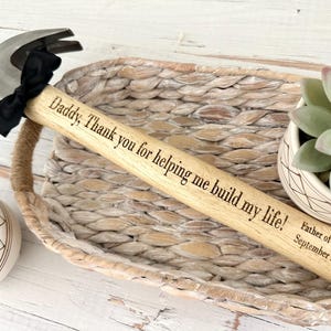 May include: A wooden hammer with a black bow and the inscription "Daddy, Thank you for helping me build my life! Father of the Bride September 28, 2024".