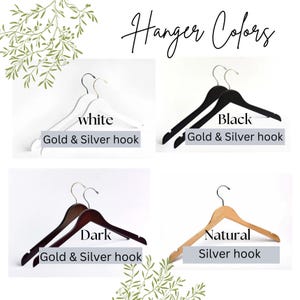 May include: Image showcasing wooden hangers in four colors: white, black, dark, and natural. Each hanger has a hook, with options for gold or silver finishes. The text "Hanger Colors" is displayed at the top.