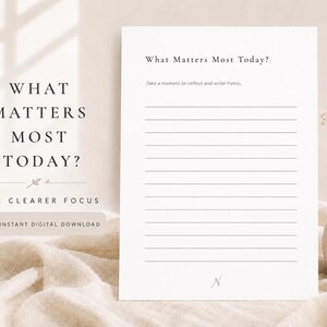 May include: A white rectangular paper sheet featuring the black text What Matters Most Today? at the top, followed by the instruction Take a moment to reflect and write freely, with twelve horizontal lines for writing and a letter N at the bottom.