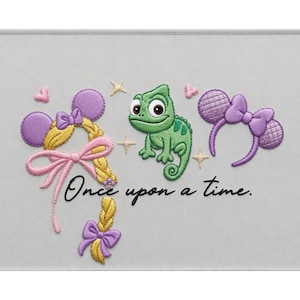 Könnte beinhalten: Ein gesticktes Design auf hellgrauem Stoff mit einem grünen Chamäleon, einer langen blonden Flechtfrisur mit rosa Schleifen und violetten Mausohren. Der Text "Once upon a time." ist in Schwarz gestickt, akzentuiert durch kleine rosa Herzen und goldene Sterne.