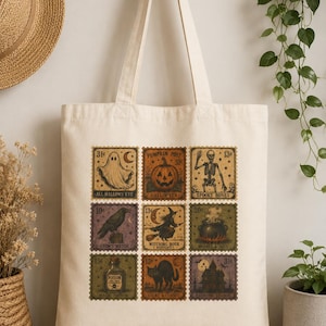 Puede incluir: Una bolsa de tela color crema con una cuadrícula de nueve ilustraciones estilo sello postal antiguo. Los diseños incluyen un fantasma, una calabaza, un esqueleto, un cuervo, una bruja, un caldero, una botella de veneno, un gato negro y una casa.