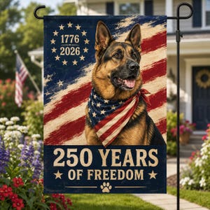 May include: A garden flag featuring a German Shepherd wearing an American flag bandana. The flag has a distressed American flag design with the text "1776 2026" and "250 YEARS OF FREEDOM". A paw print is at the bottom.