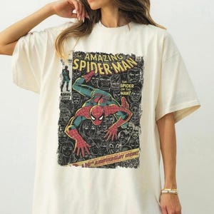 Op de afbeelding: Cr&egrave;mekleurig T-shirt met een stripboekcover-ontwerp van Spider-Man. De afbeelding bevat de tekst "The Amazing Spider-Man", "The Spider or the Man?" en "30th Anniversary Issue!". De superheld wordt in een dynamische pose afgebeeld.
