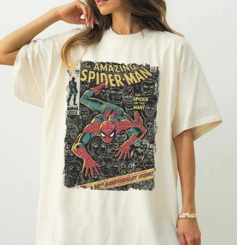 Op de afbeelding: Cr&egrave;mekleurig T-shirt met een stripboekcover-ontwerp van Spider-Man. De afbeelding bevat de tekst "The Amazing Spider-Man", "The Spider or the Man?" en "30th Anniversary Issue!". De superheld wordt in een dynamische pose afgebeeld.